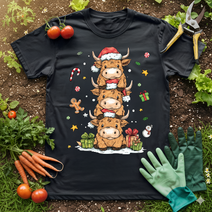 Cute Highland Cow Christmas T-Shirt featuring stacked cows in Santa hats, surrounded by festive gifts and candy canes.