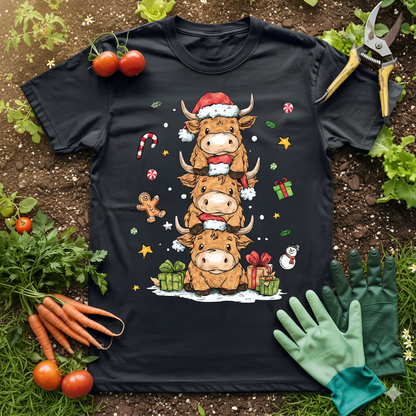 Cute Highland Cow Christmas T-Shirt featuring stacked cows in Santa hats, surrounded by festive gifts and candy canes.
